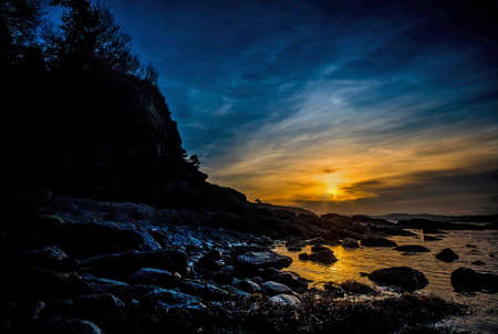Beautiful landscape of a rocky beach sunsetの写真素材