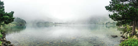 Landscape with a lake covered with fogの写真素材