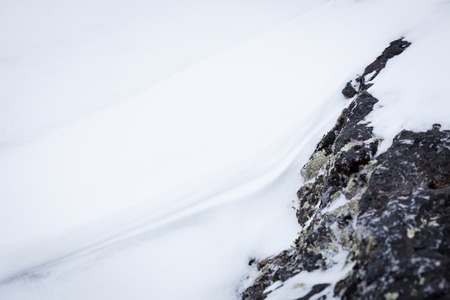 Natural white snow and rock backgroundの写真素材
