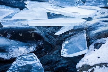 Pieces of ice and rocks at lakesideの写真素材