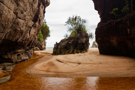 Tropical beach between two big rocks at bako national park borneo malaysiaの写真素材
