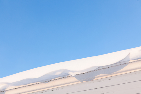 Gutter and roof full of snow in winterの写真素材