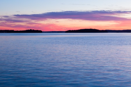 Calm sunset and clouds over lake in finlandの写真素材
