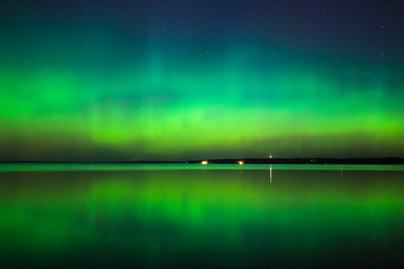 Beautiful northern lights aurora borealis over lake in finlandの写真素材
