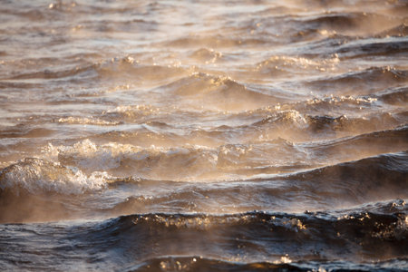 Water vapor on surface of cold icy water at sunny cold winter day