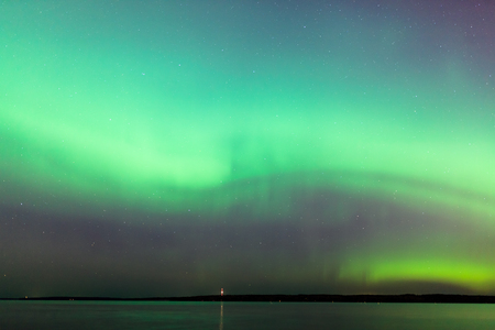 Beautiful northern lights aurora borealis over lake in finlandの写真素材