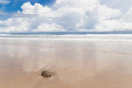 Waves sand beach and clouds sunny dayの写真素材