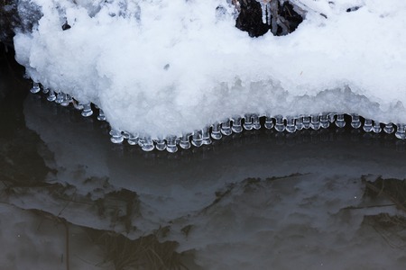 Small round icicles over waterの写真素材