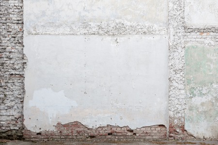 Broken old white plaster brick wallの写真素材