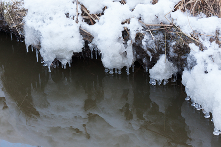 Small round icicles over water perfect reflectionの写真素材