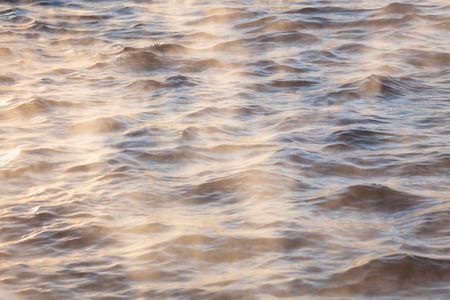 Water vapor on surface of cold icy water at sunny cold winter dayの写真素材
