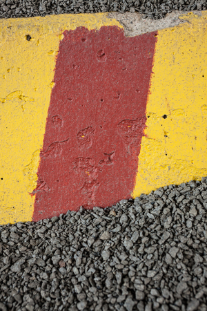 Worn concrete roadblock in gravelの写真素材
