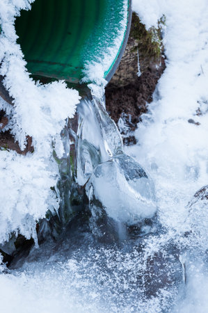 Ice and water from underground drain close view
