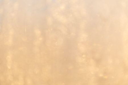Frost in window at warm sunlight defocused background
