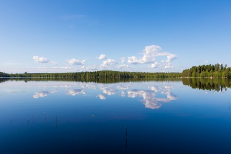 Sky reflects from still lake at summer dayの写真素材