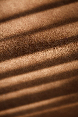 Brown sofa fabric and shadows from window blinds close-up