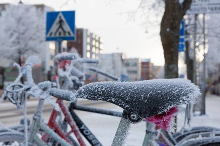 Bicycle covered in frost close-up at winter day in cityの写真素材