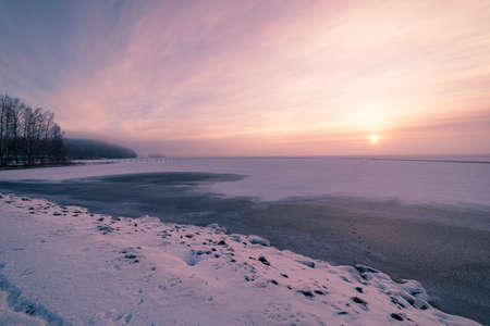 Sun through fog at lake winter morning landscapeの写真素材