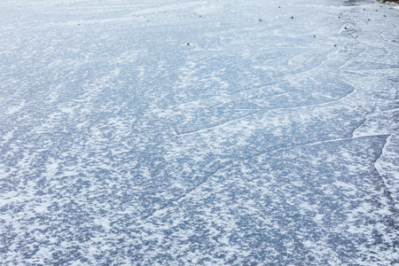 Frozen lake surface and snow at winter dayの写真素材