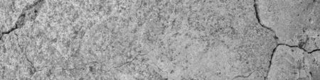 A high resolution old concrete cement with cracks and natural destruction from time and weather conditions. Non-color, monochrome black and white photo.の写真素材