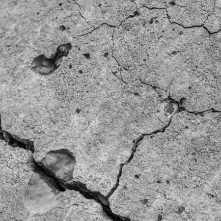 A high resolution old concrete cement with cracks and natural destruction from time and weather conditions. Non-color, monochrome black and white photo.の写真素材