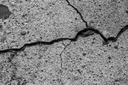 A high resolution old concrete cement with cracks and natural destruction from time and weather conditions. Non-color, monochrome black and white photo.の写真素材