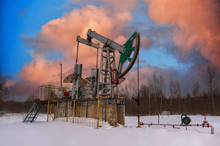 Oil pumpjack winter work is the overground drive for a reciprocating piston pump in an oil well. It is used to mechanically lift liquid out of the well. Oil pump jack.の写真素材