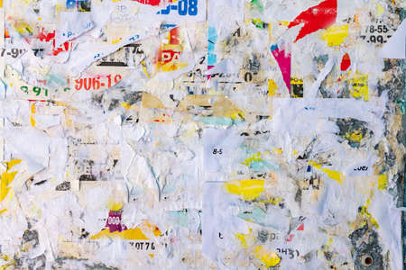 Old grunge ripped torn vintage collage colorful street posters creased crumpled paper surface placard texture background backdropの写真素材