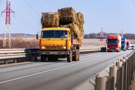 Tatarstan, Russia, Interstate Highway M7 - Apr 14th 2021. Truck KAMAZ with sheaves of hay move along the federal highway to their destination.のeditorial素材