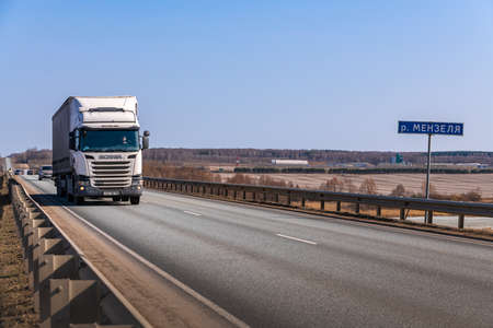 Tatarstan, Russia, Interstate Highway M7 - Apr 14th 2021. SCANIA Truck move along the federal highway to their destination. Menzel river crossing signのeditorial素材