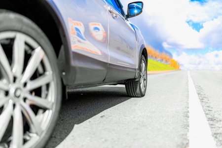 Wheel of Car on asphalt road in summer, standing on the Road Beautiful day at Countryside green forest, nature street with copyspaceの写真素材