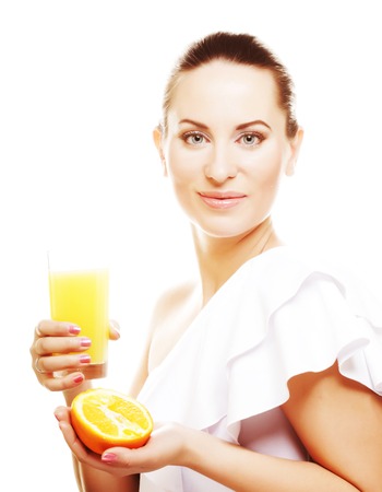 Woman drinking orange juice smiling showing oranges.の写真素材
