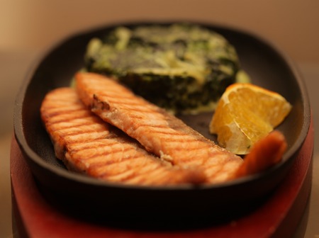 salmon steak served with spinachの写真素材