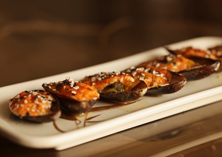 delicious baked mussles on white plateの写真素材