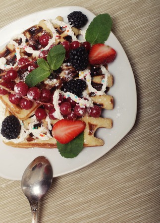 waffles with strawberry and blackberry, over white plateの写真素材