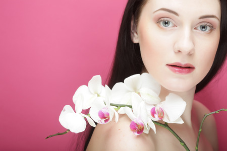 Beautiful healthy woman with orchid flower.の写真素材