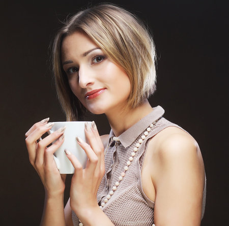 young pretty woman drinking coffeeの写真素材