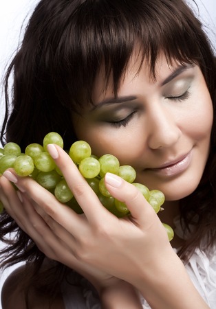 young woman with green grapesの写真素材