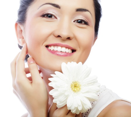 young asian woman holding white gerber flowerの写真素材