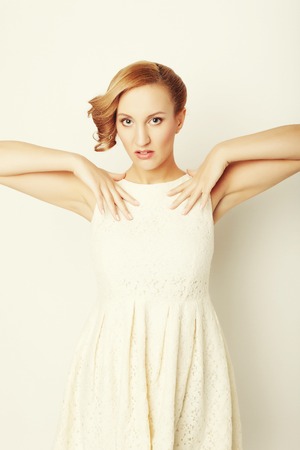 young blonde in white dress posingの写真素材