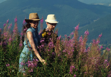 Beautiful young couple hugging and kissing on a summer holiday, Mountain, outdoors. Romantic travel and healthy lifestyle, exterior.の写真素材