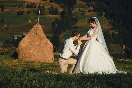 Beautiful wedding in the mountains, a young happy couple near the hayloft.の写真素材