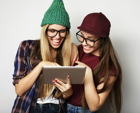lifestyle and people concept:  two hipster girls friends use digital tabletの写真素材