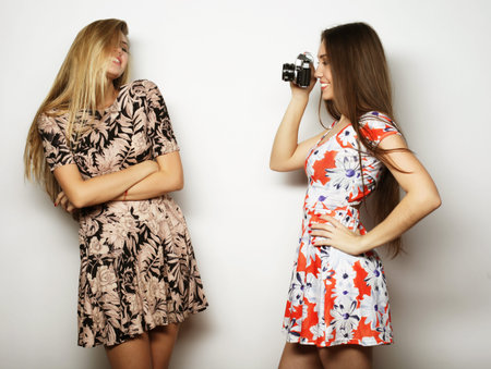 lifestyle and people concept: Happy girls friends taking some pictures, over grey background