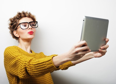 lifestyle and people concept: happy woman taking selfie with digital tabletの写真素材