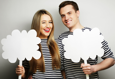 couple, love and family concept: amorous couple holding blank paper on stick.の写真素材