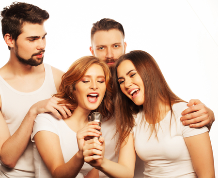 People, friendship  and leisure concept: group of young happy friends  having fun at karaoke, hipster style.Isolated on white.の写真素材