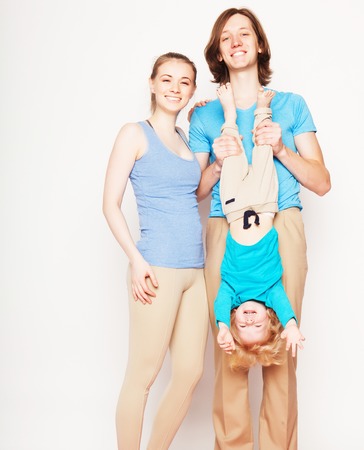 Happy sporty family - mother, father and little son posing over white backgroundの写真素材
