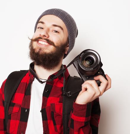 life style, tehnology and people concept: professional photographer. Portrait of confident young man in shirt  holding  camera over white backgroundの写真素材