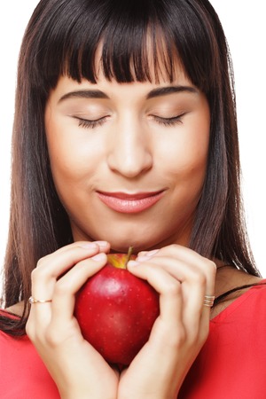 People, health and diet concept: beautiful brunette woman with red apple in handsの写真素材